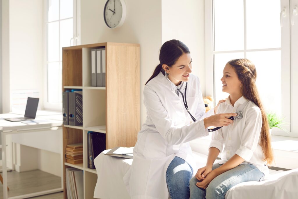 Female doctor using a stethoscope to examine a young girl during a medical checkup